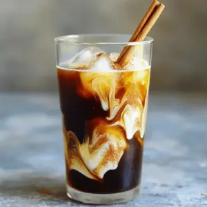 - Coffee: Use coarsely ground coffee for the best cold brew. A medium roast works great. - Honey: Choose raw honey for a rich flavor. It adds a nice touch of sweetness. - Cinnamon: Ground cinnamon gives you a smooth blend. You can also use cinnamon sticks for garnish. - Milk Options: You can use regular milk or dairy-free choices like almond or oat milk. - Garnish: Consider a cinnamon stick for a pretty look and added flavor. This mix of ingredients creates a drink that’s tasty and refreshing. You can adjust each item based on your taste. To start, take one cup of coarsely ground coffee. Mix it with four cups of cold water in a large pitcher. Stir gently to ensure all the coffee grounds soak up the water. Cover the pitcher with a lid or plastic wrap. Let it steep in the fridge for 12 to 24 hours. The longer you steep, the stronger your cold brew will be. After steeping, it’s time to strain the coffee. You can use a fine-mesh sieve or a coffee filter. If you want a clearer drink, a coffee filter works best. Pour the coffee through your chosen method to remove all the grounds. Make sure not to rush this step; a good strain helps improve the flavor. Now, let’s make the sweet honey cinnamon mix. In a small bowl, combine two tablespoons of honey and one teaspoon of ground cinnamon. Mix them well until it becomes a smooth paste. If the honey feels too thick, warm it slightly in the microwave. This step helps to blend the flavors better. In a glass, add a few tablespoons of your honey cinnamon mixture. Next, pour in the cold brew concentrate. Use as much concentrate as you like for your coffee strength. Then, stir in half a cup of milk or your favorite dairy-free alternative. Adjust the milk based on how creamy you want your drink. Finally, fill the glass with ice cubes, mix well, and taste. You can add more honey or cinnamon if you want a sweeter or spicier kick. For a fancy touch, add a cinnamon stick for garnish. Enjoy your refreshing drink! To get the best flavor, choose the right coffee. I suggest using coarsely ground coffee for a smooth taste. If you like strong coffee, increase the coffee ratio. For a lighter drink, use less coffee. Sweetness is key too. Start with two tablespoons of honey. You can add more if you like it sweeter. One mistake is over-steeping the coffee. If you steep for too long, it may taste bitter. Aim for 12 to 24 hours for the best taste. Another mistake is not mixing honey and cinnamon well. Make sure they form a smooth paste. If your honey is thick, warm it a bit to make it easier to mix. Serve your drink in a tall glass to show off its layers. You can use ice cubes for a refreshing look. For a special touch, add a cinnamon stick as a garnish. This will look nice and add extra flavor. If you want to get creative, try adding whipped cream on top. {{image_2}} You can easily change the flavor of your Honey Cinnamon Cold Brew. Try adding nutmeg for warmth. Just a pinch can make a big difference. You could also use vanilla extract. It adds a sweet note that pairs well with cinnamon. For a chocolate twist, mix in cocoa powder. Each option brings a new taste to your drink. If you want to reduce sugar, consider substitutes like stevia or agave. These work well and keep the taste great. You can also adjust the honey amount. Some like it sweeter, while others prefer a milder flavor. Taste as you go to find your perfect balance. You don't have to stick to one coffee type. Try different beans to discover new flavors. Light roasts offer fruity notes, while dark roasts bring rich, bold flavors. Cold brew differs from iced coffee in how you prepare it. Cold brew steeps for hours, giving a smooth taste. Iced coffee uses hot brewed coffee poured over ice. Each method brings its own unique flavor. To keep your cold brew concentrate fresh, store it in the fridge. Use a clean, airtight container. This helps prevent any unwanted flavors from mixing in. The cold brew concentrate stays good for about two weeks. After that, the flavor may fade. Once you mix honey cinnamon cold brew, it tastes best fresh. If you store it, use it within three days. For reheating, warm it gently on the stove or in the microwave. You may prefer making fresh servings for the best taste. Always add ice when serving to keep it cold and refreshing. Cold brew coffee needs to steep for 12 to 24 hours. If you like strong coffee, go for the longer time. If you want a milder taste, steep for about 12 hours. The longer the brew, the richer the flavor. Yes, you can use other sweeteners. Here are some great options: - Maple syrup: Adds a nice flavor. - Agave nectar: A light and sweet choice. - Stevia: A no-calorie option for those watching sugar intake. - Brown sugar: Gives a deeper flavor with a hint of molasses. Feel free to adjust the amount based on your taste. Yes, this recipe works well for iced coffee lovers. Cold brew differs from iced coffee because it uses cold water instead of hot. This method gives a smoother, less bitter taste. Cold brew packs a stronger flavor, making it perfect for hot days. You can find Honey Cinnamon Cold Brew at many cafés and stores. Popular brands often sell ready-made versions. Some cafes even offer this drink as a seasonal special. Check your local coffee shops or grocery stores for options. In this blog post, we explored how to make a delicious honey cinnamon cold brew. We covered key ingredients, step-by-step brewing, and tips to perfect your drink. Remember, the right coffee grind and steeping time matter a lot. Mixing honey and cinnamon just right boosts flavor. You can also experiment with various spices and sweeteners to find your perfect blend. Keep your cold brew fresh by storing it properly. Enjoy your tasty drink with confidence and impress your friends with your skills!