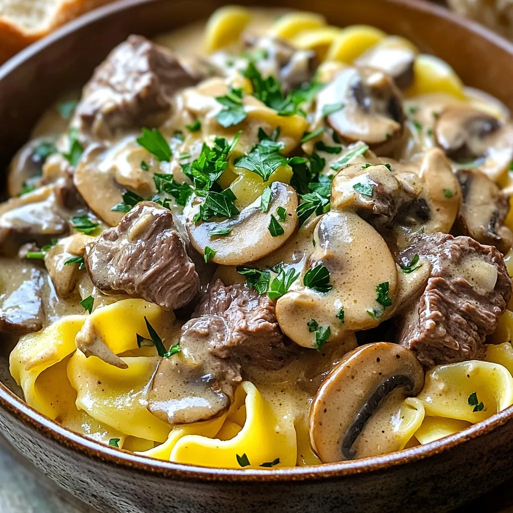 To make Slow Cooker Beef Stroganoff with Egg Noodles, gather these items: - 1.5 lbs beef stew meat, cut into bite-sized pieces - 1 medium onion, finely chopped - 3 cloves garlic, minced - 8 oz mushrooms, sliced (button or cremini) - 1 cup beef broth - 1 tablespoon Worcestershire sauce - 2 teaspoons Dijon mustard - 1 teaspoon dried thyme - Salt and pepper to taste - 1 cup sour cream - 2 tablespoons all-purpose flour (optional for thickening) - 12 oz egg noodles - Fresh parsley, chopped for garnish You can swap ingredients easily if needed: - Use chicken or turkey instead of beef for a lighter option. - Replace fresh mushrooms with canned ones for convenience. - Greek yogurt can stand in for sour cream if you want a healthier choice. - Use vegetable broth instead of beef broth for a vegetarian version. - For gluten-free dishes, try gluten-free pasta or rice noodles. This dish serves six people and is hearty. Here’s the nutritional breakdown per serving: - Calories: Approximately 400 - Protein: 30 grams - Carbohydrates: 40 grams - Fat: 15 grams - Fiber: 2 grams - Sodium: 600 mg Knowing the nutritional facts helps you plan your meals better. Enjoy this filling dish with confidence! Start by gathering all your ingredients. You will need: - 1.5 lbs beef stew meat, cut into bite-sized pieces - 1 medium onion, finely chopped - 3 cloves garlic, minced - 8 oz mushrooms, sliced - 1 cup beef broth - 1 tablespoon Worcestershire sauce - 2 teaspoons Dijon mustard - 1 teaspoon dried thyme - Salt and pepper to taste - 1 cup sour cream - 2 tablespoons all-purpose flour (optional) - 12 oz egg noodles - Fresh parsley, chopped First, chop the onion and mince the garlic. Next, slice the mushrooms. This prep makes your cooking smooth and easy. In your slow cooker, place the beef stew meat at the bottom. Layer the chopped onion, minced garlic, and sliced mushrooms on the beef. In a bowl, mix the beef broth, Worcestershire sauce, Dijon mustard, dried thyme, salt, and pepper. Pour this mix over the beef and veggies in the slow cooker. Cover the cooker and set it on low for 7-8 hours or high for 4-5 hours. The beef should be very tender when it’s done. If you prefer a thicker sauce, mix flour with a little water in a cup. Stir this slurry into the slow cooker along with the sour cream about 10-15 minutes before the meal is ready. About 30 minutes before you want to eat, cook the egg noodles. Bring a pot of water to a boil. Add the noodles and follow the package instructions for timing. Once cooked, drain the noodles and set them aside. When the beef stroganoff is ready, gently fold in the cooked egg noodles. Mix until everything is well combined. Taste the dish and adjust the seasoning if needed. Serve hot with a sprinkle of fresh parsley on top. Enjoy your delicious meal! To make a thicker sauce, use flour. Mix two tablespoons of flour with a little water. This makes a slurry. Stir it into the slow cooker with the sour cream. Let it cook for 10 to 15 more minutes. This helps the sauce get creamy and rich. You can boost the flavor of your beef stroganoff. Add a splash of red wine for depth. You can also use fresh herbs like rosemary or bay leaves. They add a nice touch. For a spicy kick, try adding a pinch of cayenne pepper. This gives the dish more warmth and excitement. If you are short on time, cook on high for 4 to 5 hours. For more tender beef, use low heat for 7 to 8 hours. Always check the beef. It should be fork-tender when done. If you need to speed up cooking, cut the beef into smaller pieces. This helps it cook faster and become tender. {{image_2}} You can swap beef for other meats. Chicken, pork, or turkey work well. Use 1.5 lbs of your choice. Cook times may change slightly. Chicken may cook faster, while pork takes about the same time. Ground meats are also great. They cook quickly and soak up flavors. Add more veggies for extra flavor and nutrients. Carrots, peas, or bell peppers fit nicely. Sliced carrots add sweetness and color. Peas bring a pop of green and texture. Bell peppers add crunch. Just chop them small and toss them in with the other veggies. You will enjoy the new tastes. To make this dish gluten-free, use gluten-free flour. You can thicken the sauce with cornstarch instead of regular flour. Just mix 1 tablespoon of cornstarch with water. Stir it into the slow cooker near the end. For noodles, choose gluten-free egg noodles or another gluten-free pasta. Enjoy the same rich flavors without the gluten! Keep leftover beef stroganoff in an airtight container. Store it in the fridge for up to three days. Make sure it cools completely before sealing. Label the container with the date to track freshness. You can freeze beef stroganoff for later use. Place it in a freezer-safe container or bag. Remove as much air as possible to prevent freezer burn. It stays good for up to three months. Remember to freeze it before adding the sour cream for best results. To reheat, thaw the stroganoff in the fridge overnight if frozen. Heat it gently on the stove over low heat. Stir occasionally to make sure it warms evenly. If it seems thick, add a splash of beef broth or water to loosen it up. You can also microwave it in short bursts, stirring in between. Enjoy again with fresh egg noodles or crusty bread! Yes, you can use several types of meat. Chicken, pork, or turkey work well. Just adjust the cooking time. Chicken cooks faster, while pork and turkey may take a bit longer. You can also use ground beef for a quicker version. Ground beef cooks fast and gives a nice texture. Think about your taste and what you have on hand. To make this dish vegetarian, swap the beef for mushrooms or lentils. Use vegetable broth instead of beef broth. You can add more veggies like bell peppers or carrots for flavor and texture. Tofu is another great option. It absorbs the sauce well and adds protein. Make sure to adjust cooking times if you change the protein. Serve this dish with egg noodles, as they soak up the sauce well. You can also pair it with rice or mashed potatoes for a hearty meal. A side of crusty bread is perfect for dipping. Salads with greens can add freshness to the meal. Consider a simple green salad with a light dressing. This post covered how to make Slow Cooker Beef Stroganoff. We explored the ingredients, substitutes, and their nutritional value. I shared step-by-step instructions that include cooking the beef and noodles. We also covered tips for thickening the sauce and boosting flavors. For variations, I discussed protein swaps and veggie add-ins. Lastly, we went over storage tips and FAQs to make life easier. Now you can enjoy this hearty meal with ease and confidence.